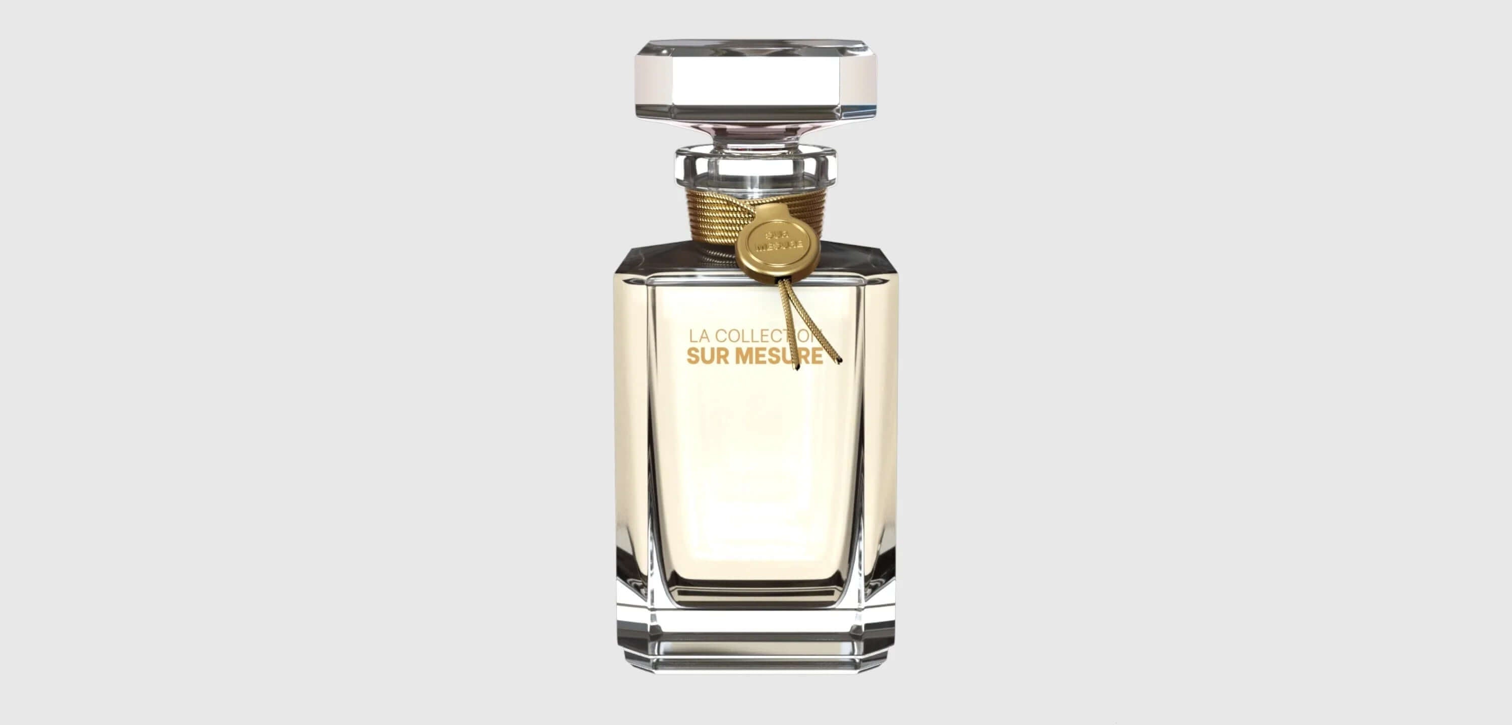 Luxury clear glass perfume bottle with gold cap and label reading 'La Collection Sur Mesure'
